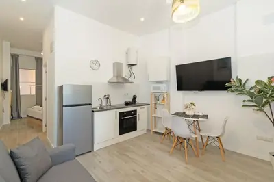 a kitchen and living room with a table and a refrigerator at GuestReady - Bright home in Valencia in Valencia