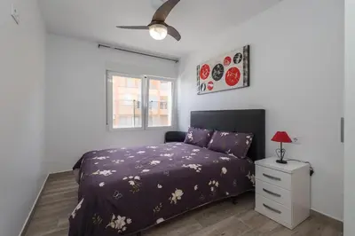 a bedroom with a purple bed and a window at Villa Prestige Beach in Mareny Barraquetas
