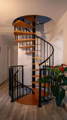 a spiral staircase in a living room with a plant at Villa Prestige Beach in Mareny Barraquetas