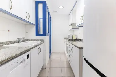 a kitchen with white cabinets and a sink at ApartUP Patacona Splendor in Valencia