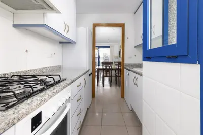 a kitchen with white counter tops and blue cabinets at ApartUP Patacona Splendor in Valencia