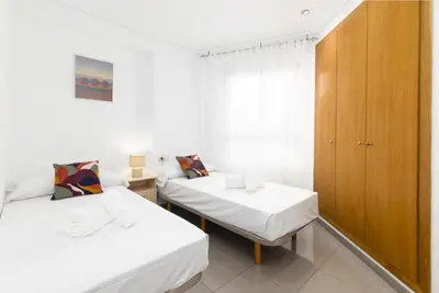 a room with two beds and a cabinet at ApartUP Patacona Splendor in Valencia