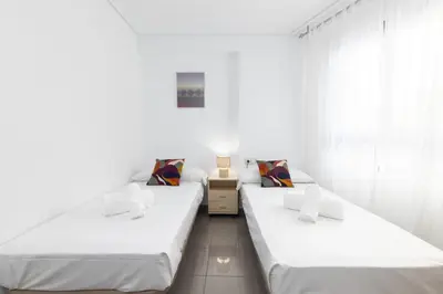 two beds in a room with white walls at ApartUP Patacona Splendor in Valencia