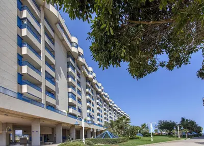 a large building with a blue sky in the background at ApartUP Patacona Splendor in Valencia