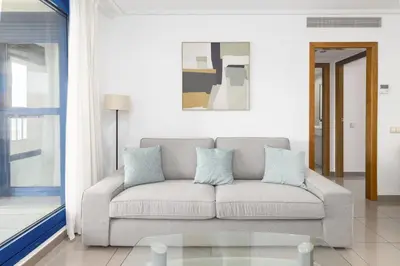 a living room with a couch and a window at ApartUP Patacona Splendor in Valencia