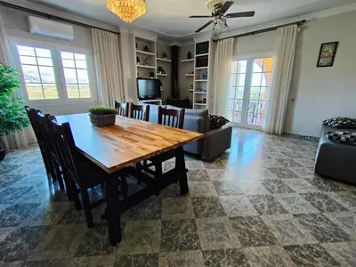 a living room with a wooden table and chairs at VILLA ALGUER - Chalet junto a la playa del Marenyet de Cullera in Cullera