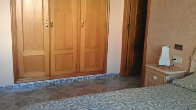a bedroom with wooden cabinets and a bed and a lamp at VILLA ALGUER - Chalet junto a la playa del Marenyet de Cullera in Cullera