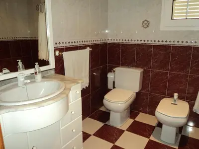 a bathroom with a toilet and a sink at VILLA ALGUER - Chalet junto a la playa del Marenyet de Cullera in Cullera