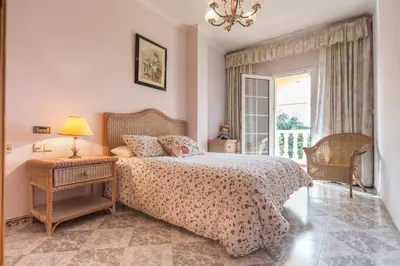 a bedroom with a bed and a table with a lamp at VILLA ALGUER - Chalet junto a la playa del Marenyet de Cullera in Cullera