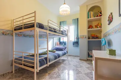 a bedroom with two bunk beds in a room at VILLA ALGUER - Chalet junto a la playa del Marenyet de Cullera in Cullera