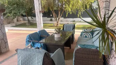 a hammock in the middle of a courtyard at Villa Jazmín - Piscina - BBQ - Jardín - Chill out in Masía Aldamar