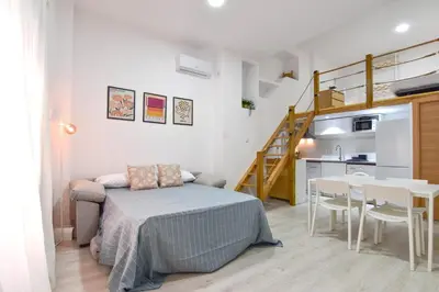 a bedroom with a bed and a table and a kitchen at Alójate en el Puerto de Valencia 1 in Valencia