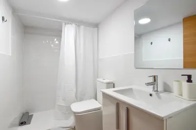 a white bathroom with a toilet and a sink at Alójate en el Puerto de Valencia 1 in Valencia
