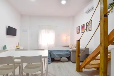 a white room with a bed and a table and chairs at Alójate en el Puerto de Valencia 1 in Valencia