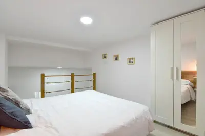 a white bedroom with a bed and a closet at Puerto de Valencia 2 in Valencia