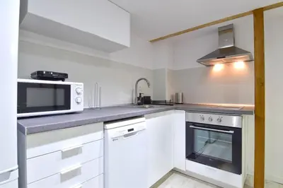 a white kitchen with a microwave and a stove at Puerto de Valencia 2 in Valencia