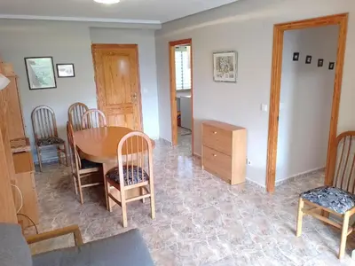 a living room with a wooden table and chairs at Van-Dyck, ESC-4, 6-24 PK 18 in Cullera