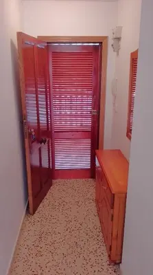 a room with a red door and a wooden desk at Sol, 3-20 in Cullera