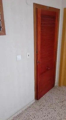 a wooden door in a room with a wall at Sol, 3-20 in Cullera