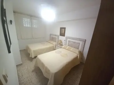 a room with two beds in a white room at Sol, 3-20 in Cullera