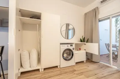 a laundry room with a washing machine and a mirror at Maritim Loft Apartment in Valencia