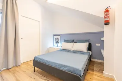a bedroom with a bed with a blue headboard at Maritim Loft Apartment in Valencia
