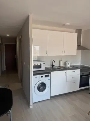 a kitchen with a washing machine and a microwave at apartamento con vistas en la playa de San Antonio in Cullera