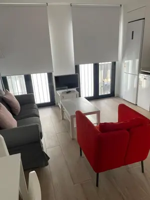 a living room with a couch and a red chair at New luxury studio in the city center in Valencia