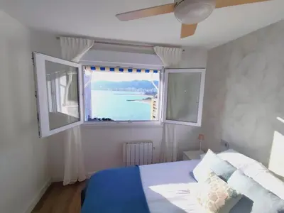a bedroom with a bed and a large window at Isla de los Pensamientos in Faro de Cullera