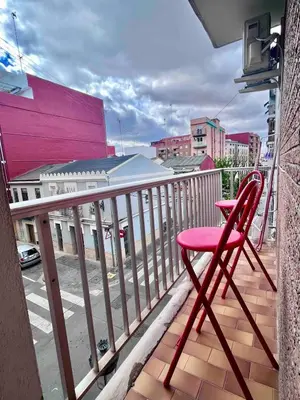 a red chair sitting on top of a balcony at Cerca de Playa arenas con balcon in Valencia