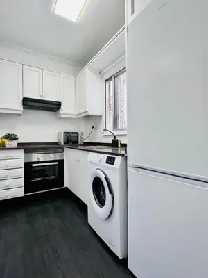 a white kitchen with a washing machine in it at Cerca de Playa arenas con balcon in Valencia