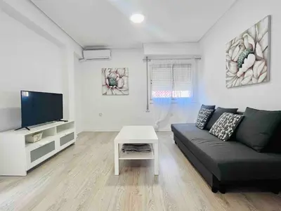 a living room with a couch and a tv at Cerca de Playa arenas con balcon in Valencia
