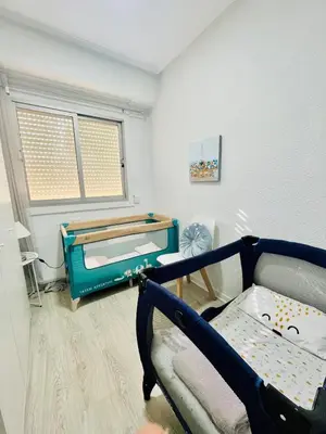 a room with a bed and a crib at Cerca de Playa arenas con balcon in Valencia