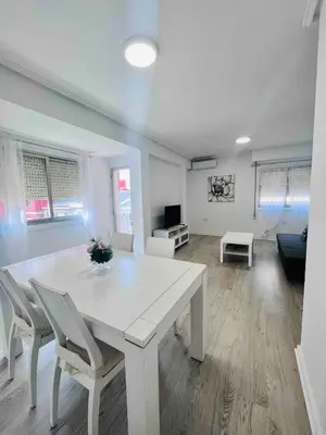a white dining table and chairs in a living room at Cerca de Playa arenas con balcon in Valencia