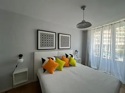 a bedroom with a white bed with colorful pillows at AmazINN Places Casa Calabuig Valencia Puerto - No Ascensor - in Valencia