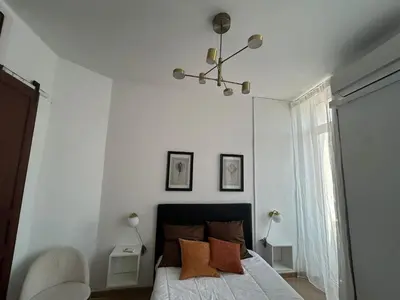 a white bed with orange pillows and two lamps at AmazINN Places Casa Calabuig Valencia Puerto - No Ascensor - in Valencia