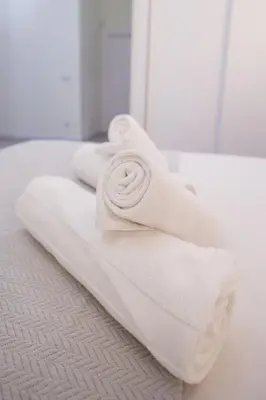 a pile of towels sitting on top of a bed at Benimamet Suite by Concept Flats in Valencia