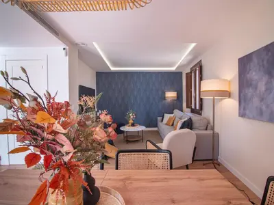 a living room with a couch and a table with flowers at MD Villa Barraques de Lluna in Valencia