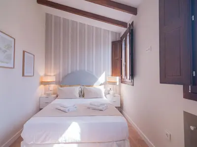a bedroom with a white bed with two towels on it at MD Villa Barraques de Lluna in Valencia