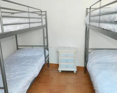 two bunk beds in a room with a night stand at Piso Playa de Canet in Canet de Berenguer