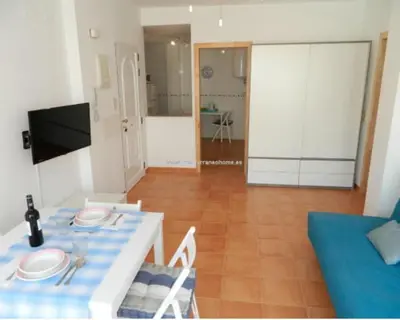 a living room with a table and a blue couch at Piso Playa de Canet in Canet de Berenguer