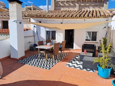 a patio with a table and chairs on a house at Apartamento Rural La Manchega in Villar del Arzobispo