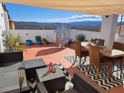 a patio with a table and chairs on a balcony at Apartamento Rural La Manchega in Villar del Arzobispo