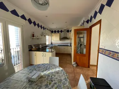 a kitchen with a table and a kitchen with blue accents at Ca Ona in Chella