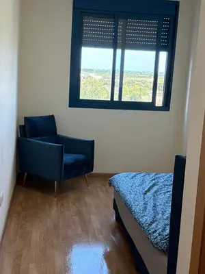a bedroom with a bed and a chair and a window at Seira Apartment in Burriana