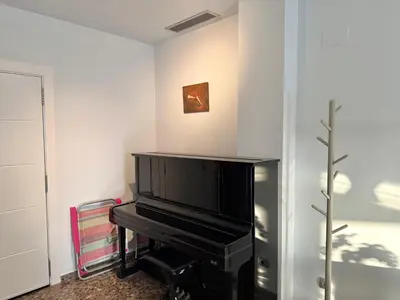 a living room with a piano and a picture on the wall at Apartamento turístico Playa Valencia in Valencia