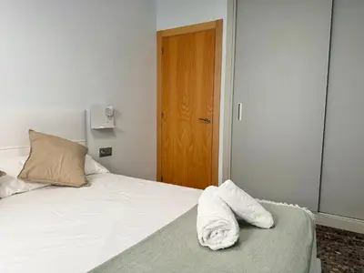 a bed with a white towel sitting on top of it at Apartamento turístico Playa Valencia in Valencia