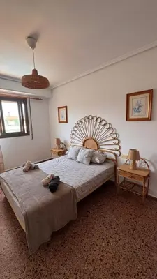 a bedroom with a large bed with a large headboard at Apartamento entero Playa Perello Valencia in El Perelló