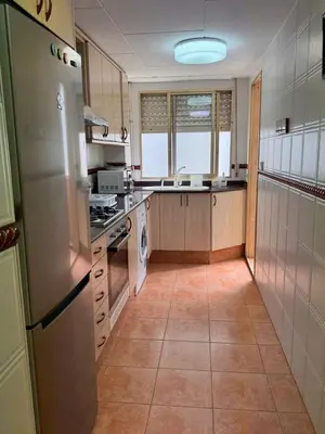 a kitchen with a refrigerator and a stove top oven at Apartamento entero Playa Perello Valencia in El Perelló