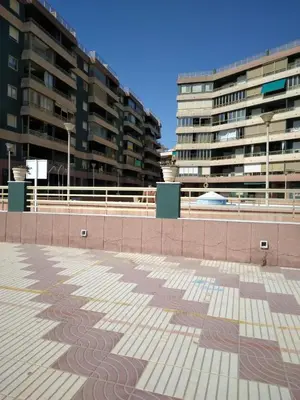 a tiled floor with two tall buildings in the background at Apartamento entero Playa Perello Valencia in El Perelló